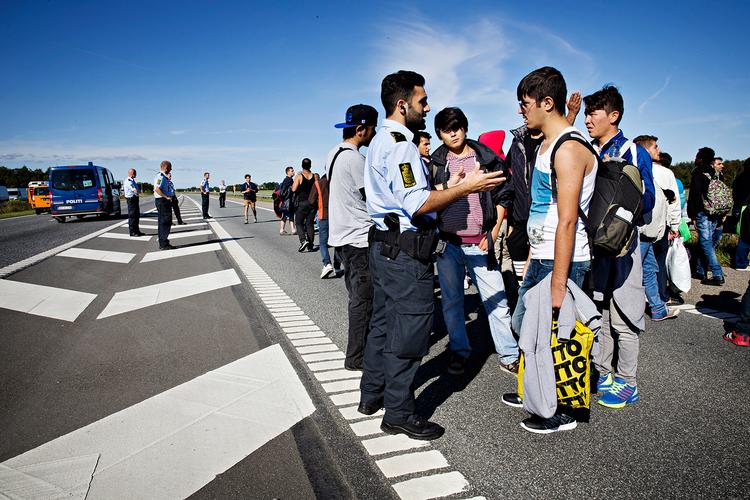 To af politiets betjente kan tale henholdsvis arabisk og afghansk pashto. Her er politi og flygtninge i snak midt i en kort pause. 