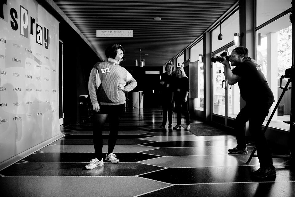 Før de 60 aspiranter går på scenen, bliver de alle iført en Tracy Turnblad-paryk og et lyserødt chiffontørklæde, hvorefter de får taget et billede. 