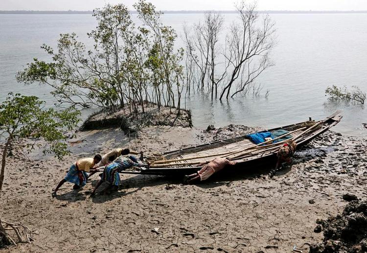 Konflikt. De konservative vil ikke være med til at skære så meget i udviklingsbistanden, som regeringen foreslår. På billedet ses indiske fiskere i Sunderbansområdet, hvor øget vandstand og oversvømmelser gør tusinder hjemløse. 