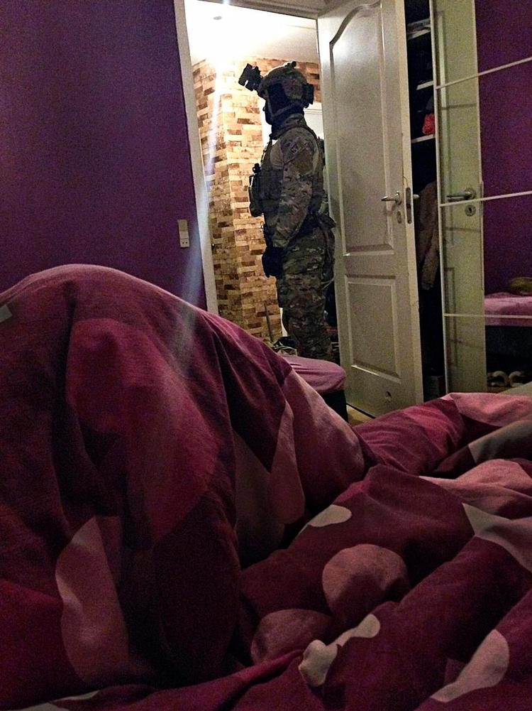 Razzia. Politiet mødte op i kamp-uniformer, da de ransagede hjem i Mjølnerparken i timerne efter terror-angrebet i København 15. februar. Billedet er taget med en mobiltelefon under ransagningen. 