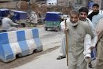 En pakistaner hjælper en mand, der er blevet såret under jordskælvet. 