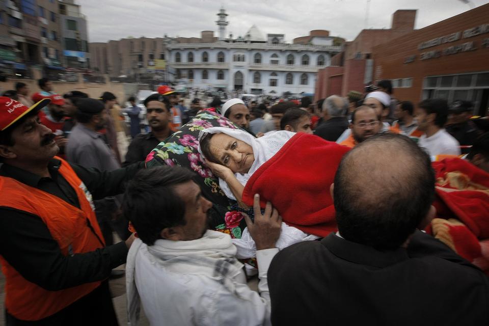 Her hjælpes en pakistansk kvinde til hospitalet. 