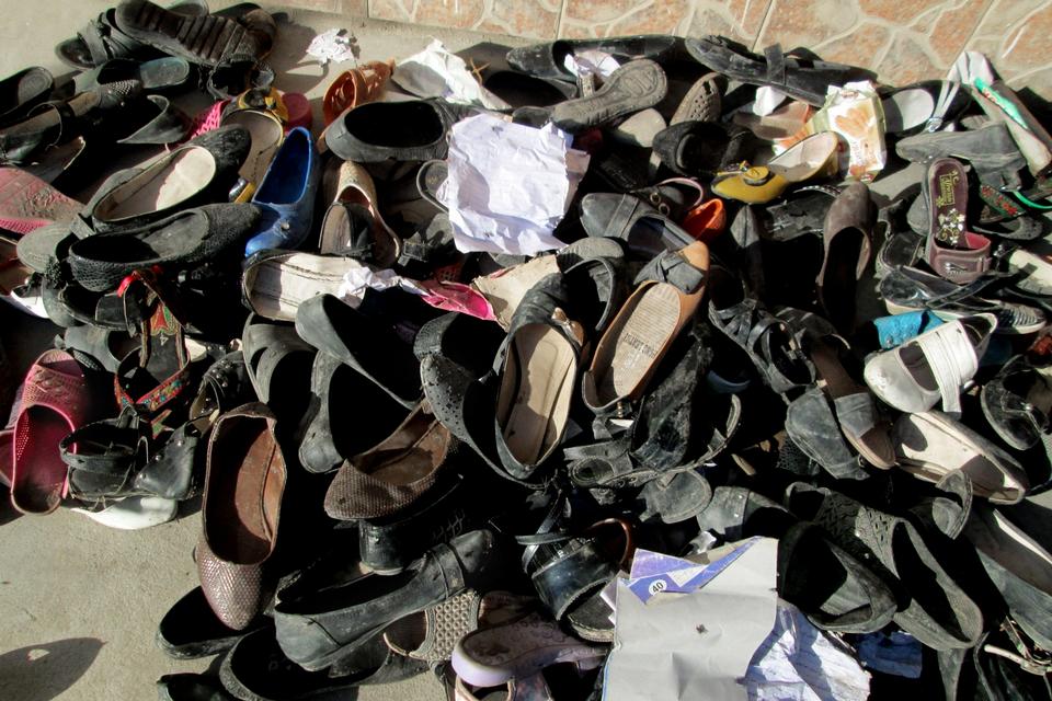 12 skolepiger mistede livet, da der udbrød panik på en skole i Takhar-provinsen i Afghanistan. Her ses efterladte sko uden for skolen. 