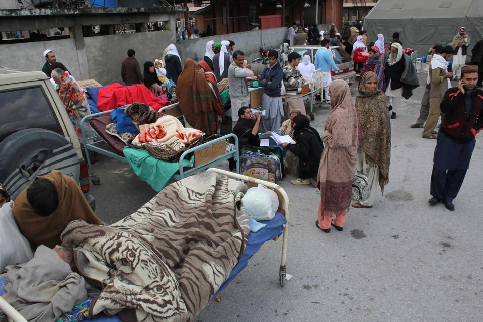 Sårede bliver behandlet uden for et hospital i byen Abbotabad i Pakistan. 