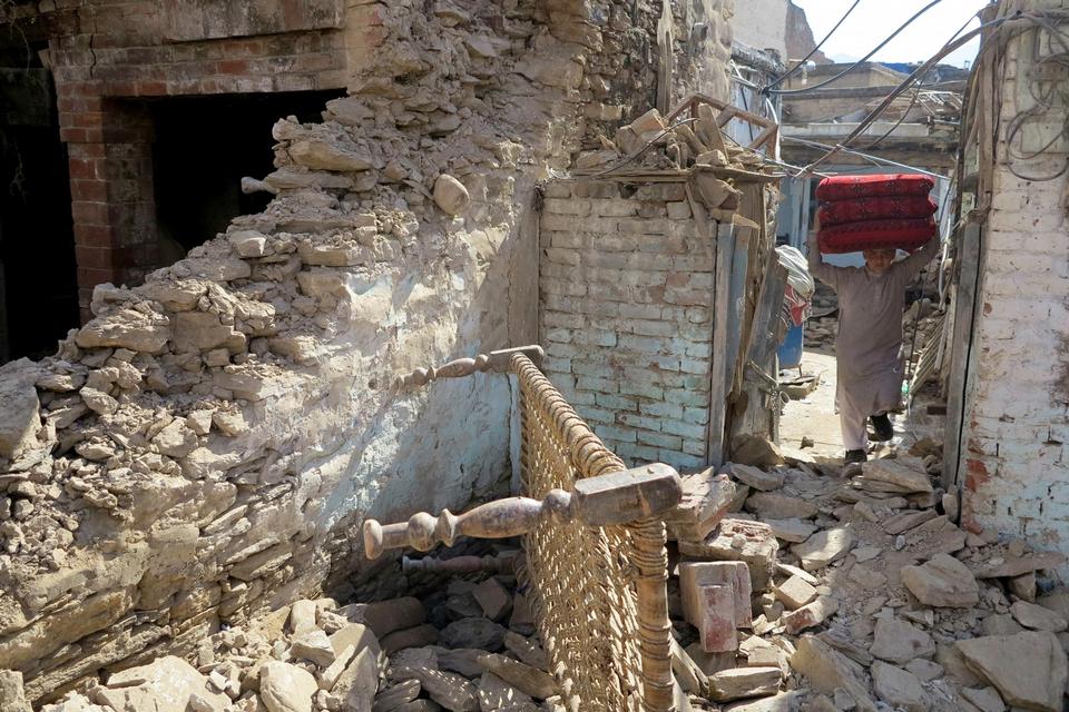 Denne mand er i gang med at fjerne sine ejendele fra sit ødelagte hus i byen Mingora i Pakistan. 