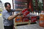 Læskebehov. En iransk lastbilchauffør læsser  Coca-Cola på en lastbil i Teheran. Men flere byer i Mellemøsten kan risikere at blive ubeboelige på grund af klimaforandringer. 