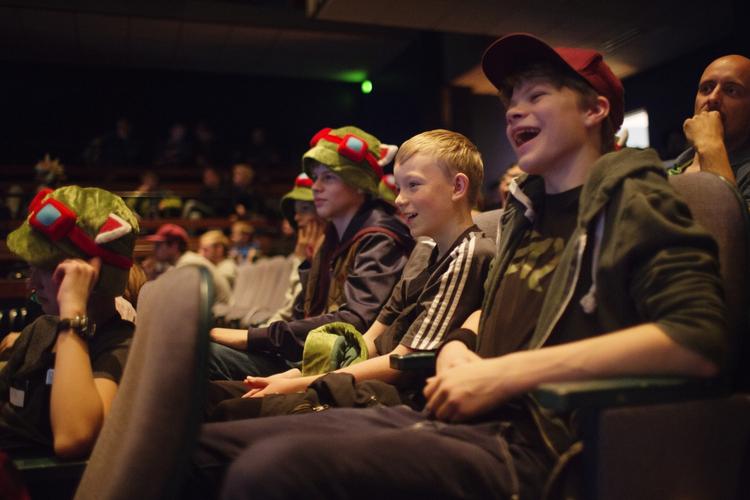 FANS. Både voksne og unge var mødt for at se finalekampen i League of Legends. Her sidder Sigge, Valdemar og Asger. Sigge har en hat magen til karakteren 'Teemo' i spillet. 
