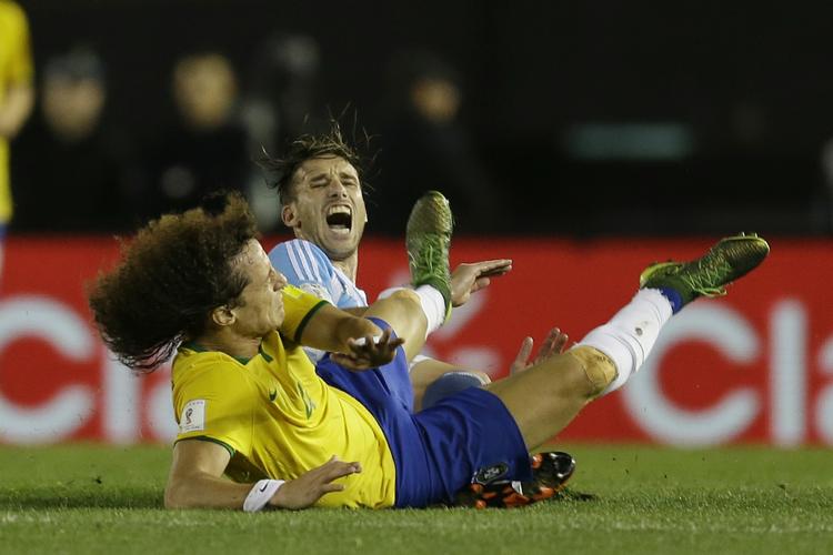 Ud. Brasiliens David Luiz fik marchordre et par minutter før tid. Her er han i clinch med Lucas Biglia. 