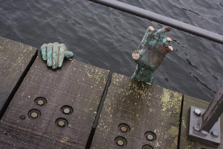 Hjælp! Giv en hånd til flygtningene, synes den anonyme kunstners i smug anbragte skulpturer at sige. Men var det nu også hans hensigt? Og - som det fremgår - er der helsingoranere, der hellere giver flygtningene fingeren end hånden. 