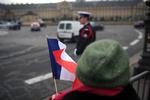 En kvinde er mødt op med det franske flag foran Les Invalides, hvor den officielle ceremoni for at markere massedrabene finder sted. 