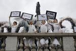 Et andet sted på pladsen står nogle damer i englekostumer som en del af en stille protest arrangeret af ngo'en Avaaz. 