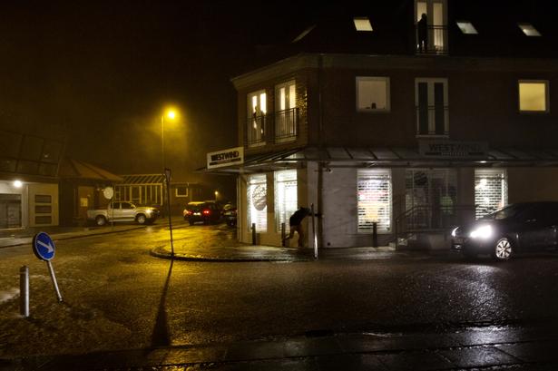 En mand klynger sig til en tagrende for at stå oprejst 