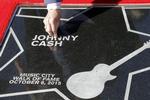 Tommy Cash, Johnny Cashs yngste bror, fjerner et blomsterblad fra storeborens stjerne, som Johnny Cash fik posthumt på Music City Walk of Fame i oktober 2015 i Nashville. 