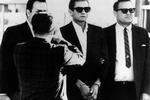 Cash er bl.a. kendt for sangen 'Folsom Prison Blues' og live-pladen 'At Folsom Prison' optaget i det amerikanske fængsel Folsom. Selv sad han aldrig i fængsel, men tilbragte dog 9 dage i arresten. På billedet fra 1965 er han netop blevet anholdt ved den mexicanske grænse med guitar-tasken fuld af piller. Han slap med en betinget dom og en bøde på $1.500. 