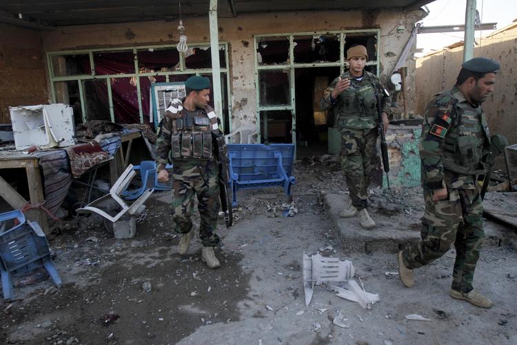 Krigsskader. Afghanske soldater gennemgår skaderne efter heftige kampe mellem Taleban og afghanske styrker i lufthavnen i Kandahar. 