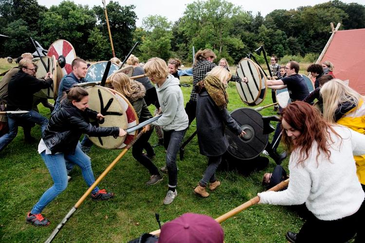 Freeemaaad! Der blev blandt andet kæmpet med sværd og skjold på rusturen i Sagnlandet i Lejre, hvor 20-årige Emilie (i den gule jakke) og de andre arkæologistuderende også spillede drukspil, skålede i flad Tuborg og delte slibrige hemmeligheder ved bålet. Foto: Peter Hove Olesen 