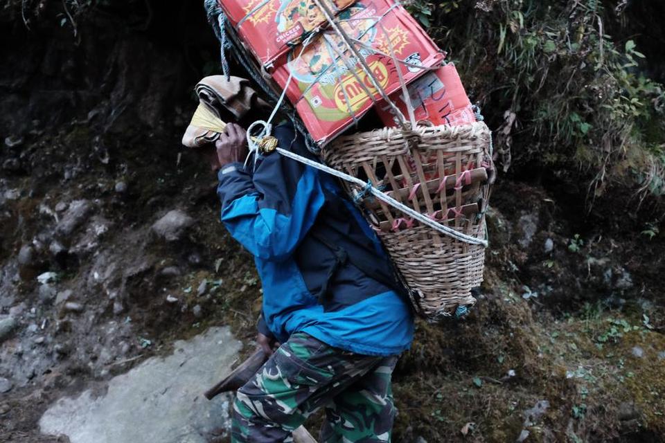 VÆGTFORDELING. Bærerne i Himalaya fordeler vægten, så ryggen ikke bliver belastet for meget. Bemærk her, hvordan det gule bånd om panden er med til at holde opbakningen på plads.