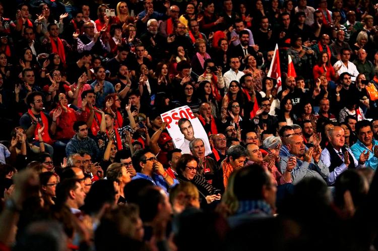 Nyt. Socialistiske partimedlemmer holder en valgplakat af leder Pedro Sánchez. Normaliteten i spansk politik er brudt, og et nyskabende valg venter i dag. 