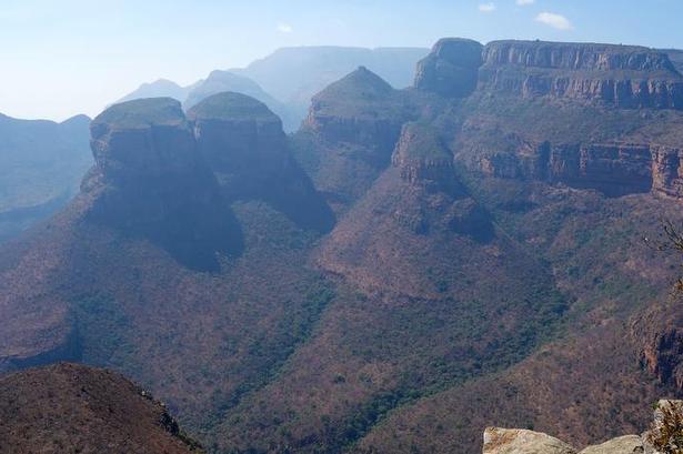 Ikonisk. The Three Rondavels midt i billedet er en del af  Mpumalanga’s Panorama Route. Engang var de kendt som de tre søstre og 'the Chief and his Three Wives'. Kært barn har mange navne. På dansk kan det oversættes til noget a la 'pavillion' og kan minde om de traditionelle runde hytter. 