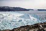 Helheim. Sydøstgrønlands største gletsjer er en af de vigtigste kanaler fra indlandsisen ud til havet. Her ses den seks kilometer brede gletsjer, mens den kælver i 2013. Den vigtigste del af billedet ligger dog i bjergene i baggrunden, hvor linjen mellem lysere og mørkere fjeld viser isens udbredelse under den lille istid frem til omtrent 1850. Arkivfoto: Nicolaj Krog Larsen, Aarhus Universitet 