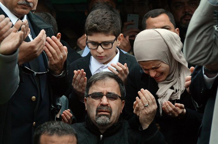 Namee Barakat, i midten, ved mindehøjtideligheden for hans søn og svigerdatter samt dennes søster. center,  watches during funeral services for his son,  Deah Shaddy Barakat,  Thursday, Feb. 12, 2015  in Wendell, N.C.  Barakat, 23, his wife, Yusor Mohammad Abu-Salha, 21, and her sister Razan Mohammad Abu-Salha, 19, were found dead Tuesday at their home near the University of North Carolina-Chapel Hill campus. Charged with three counts of first-degree murder is Craig Stephen Hicks.  (AP Photo/The News &amp; Observer, Chuck Liddy) 