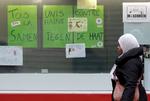 Molenbeek. En kvinde går forbi skilte med teksten ' vi er alle forenet i kampen mod had' i Molenbeek i november efter terrorangrebet i Paris. 