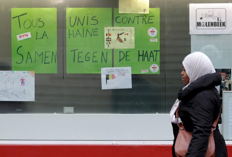 Molenbeek. En kvinde går forbi skilte med teksten ' vi er alle forenet i kampen mod had' i Molenbeek i november efter terrorangrebet i Paris. 