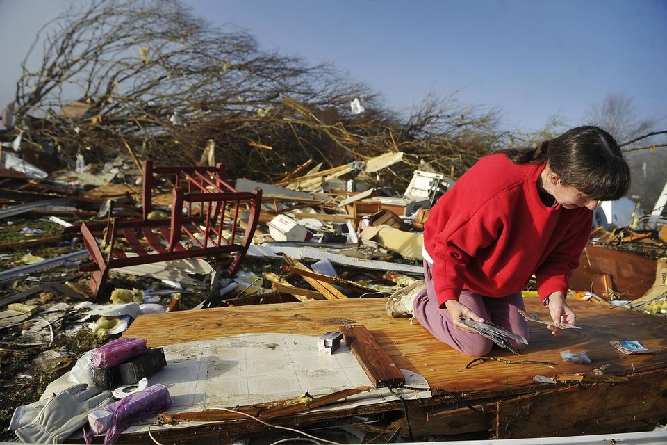 Diana Davis kigger efter familiebilleder i ruinerne af hendes svigerfars hus i Lutts, Tennessee. 