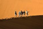 SAND. Lette sko er at foretrække i ørkenen Sosussvlei i det sydvestlige hjørne af Namibia, da du højst sandsynligt ender med at tage dem af, enten for at køle fødderne i sand, eller fordi de fyldes af det. Her balancerer guiden Athanasius og en gruppe turister mod toppen af Big Daddy. Det kan være en strabadserende tur, men også højdepunktet på besøget i Sossusvlei. 