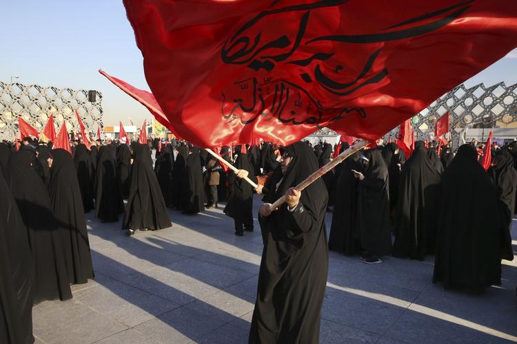 Protest. En iransk kvinde vifter med et flag, hvor der står: ’Død over Amerika og vi vil aldrig acceptere ydmygelse’. Saudi-Arabiens henrettelse af en shiamuslimsk præst lørdag har vakt vrede i Iran og skabt spændinger i en konflikt, der rækker langt ud over de to lande. 