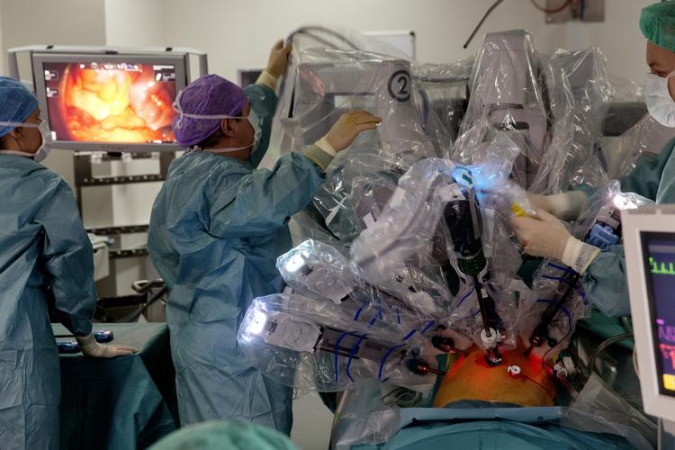 Robotkirurgi. Før operationen bliver patienten bedøvet og renset for bakterier. På billedet er kirurgerne Steen Carlsson og Mads Hvid Poulsen på Odense Universitetshospital ved at gøre de sidste forberedelser, inden Steen Carlsson på afstand skal operere Tim Andersen for hans prostatakræft. Operationen foregår ved hjælp af robottens kameraer, sakse og tænger, som er ført ind i patientens mave via robottens arme. 