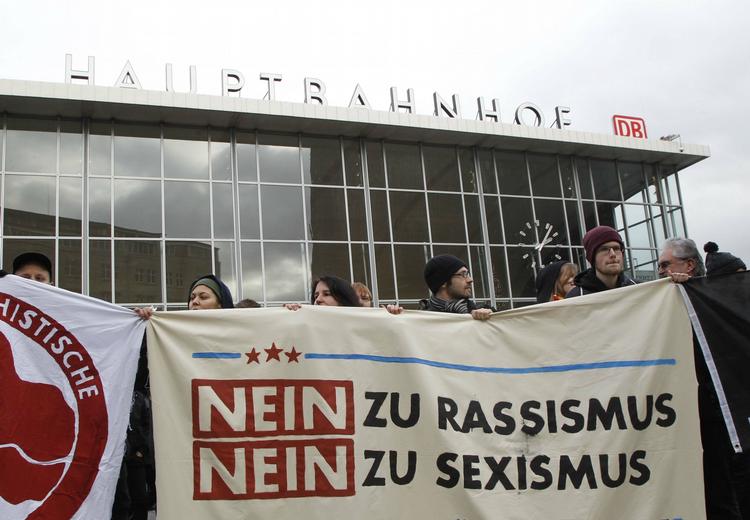 Protester. Folk protesterer mod sexisme og racisme foran togstationen i Köln. 