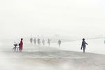 DANMARK. »Skiveren Strand ca. 30 km syd for Skagen på vesterhavssiden. En flot solskinsdag med usædvanligt stille vand, men pludselig sker der noget. Disen strømmer ind over stranden lidt længere nede, så jeg skynder mig derhen. Med ét er det ligesom at være i en helt anden verden. To mennesker er cyklet til stranden for at bade. Kvinden i en rød morgenkåbe står og venter på, at hendes mand skal komme op af vandet og frem af tågen. Længere nede ad stranden forsvinder og dukker mennesker op i tågen på mystisk vis«. Ord og foto: Lars Thomsen 