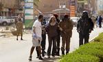 ANGREB. En kvinde føres i sikkerhed, efter terrorister i går åbnede ild på et luksushotel i Burkina Fasos hovedstad og en nærliggende café i byen. Foto: AP 