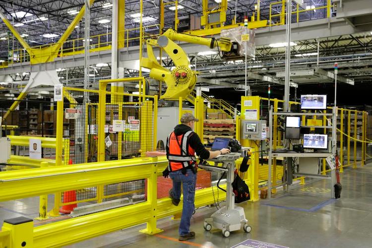 automatisk. En medarbejder styrer en robotarm på Amazons lager i DuPont, Washington. Teknologien er en afgørende faktor for Amazons konkurrenceevne. 