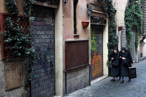 Ro. Via del Moro, et af Trasteveres hovedstrøg, der normalt myldrer med turister og lokale, er stort set tomt. To nonner går arm i arm gennem gaden, men ellers møder man ingen. 