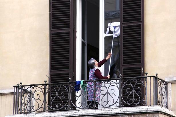 RENT. Husmødre sørger for, at morgensolen kan komme gennem vinduerne på en af det gamle Roms mest befærdede og forurenede gader, Corso Vittorio Emanuele II. 