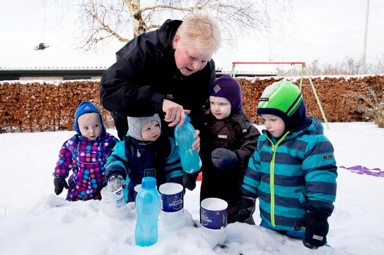 Vinterkulde. Gitte Andersen kan give børnene en tryghed, vuggestuen ikke kan. I fredags havde hun taget børnene med i haven for at lave islygter. 