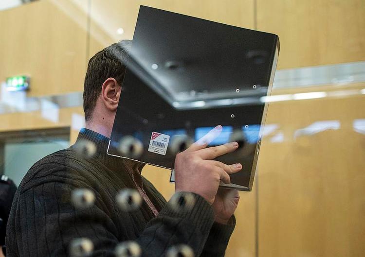 Fed. Nils D. skjult bag et ringbind, da retssagen mod ham forleden begyndte. Han var for fed til selv at blive IS- kriger. I stedet fik han til opgave at fange desertører. 