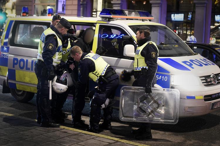 Politi. Svensk politi anholder hooligans og nazister i Sverige. Her ses en mand blive ført ind i politibil. 