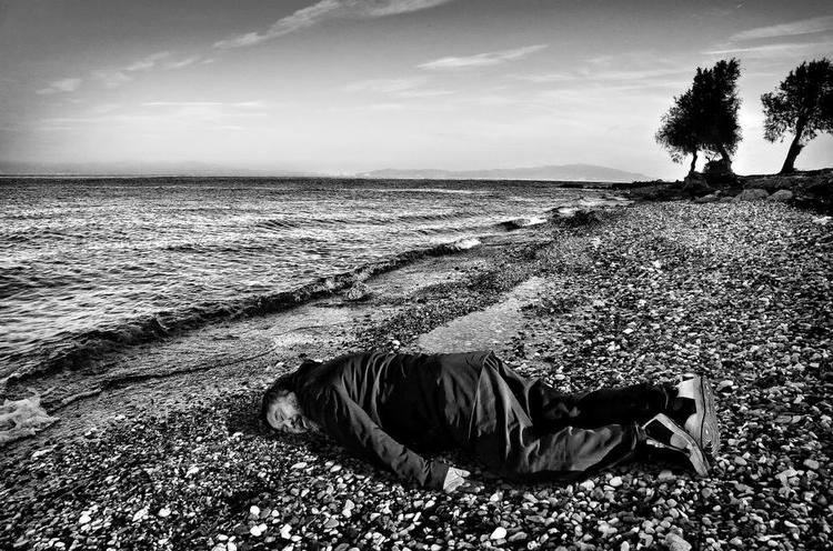 Flygtningekrise. Ai Weiwei lader sig fotografere som den lille flygtningedreng, der er skyllet op på stranden. 