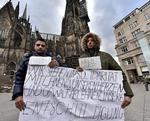 Undskyld. Mohamad fra Libanon og Nabil fra Marokko ustrykker foran katedralen i Köln deres afstandstagen fra de mange sexovergreb nytårsnat. 
