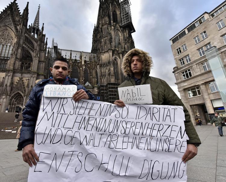 Undskyld. Mohamad fra Libanon og Nabil fra Marokko ustrykker foran katedralen i Köln deres afstandstagen fra de mange sexovergreb nytårsnat. 