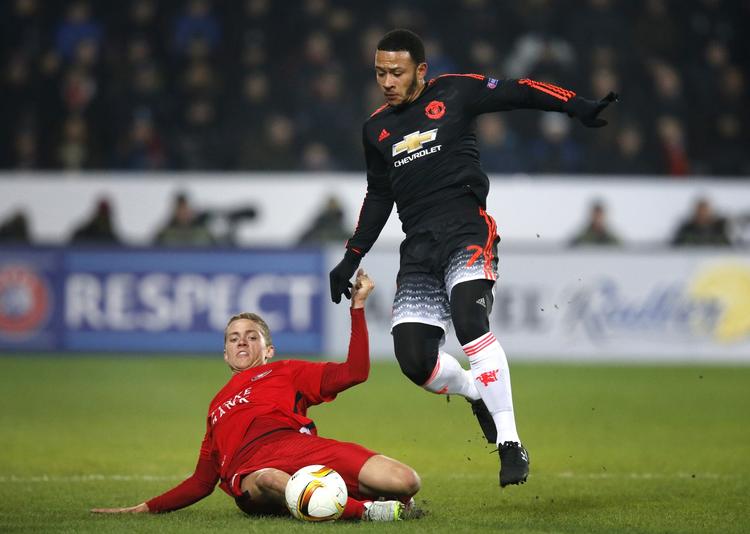 tro. FC Midtjyllands André Rømer tackler Manchester Uniteds Memphis Depay under kampen i Herning. 
