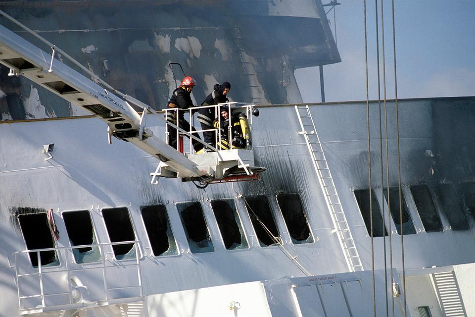 Brandfolk slukker branden i den svenske by Lysekil, efter at redningsfolk havde bugseret færgen ind i byens havn. 