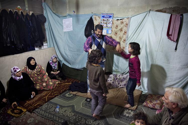Danseglæde. Adnan al-Suwayni danser med to af sine seks børn, 6-årige Fatma og Alaa på 7 år, mens resten af børneflokken kigger på. Familien er flygtet til Gaziantep i Tyrkiet fra Aleppo i Syrien for fire måneder siden. 