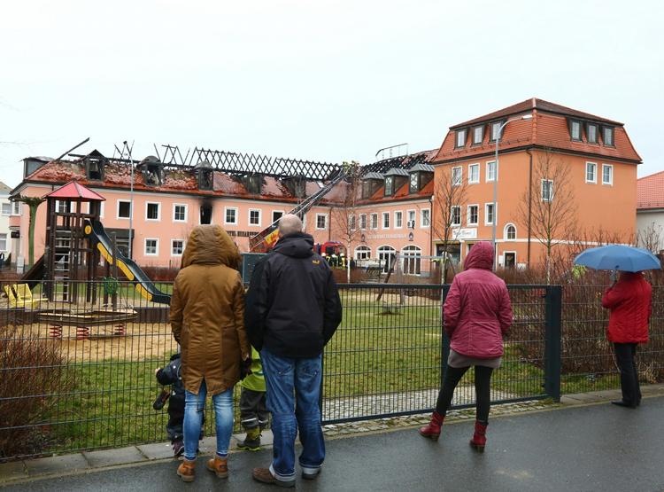 Ruin. Forbipasserende ser på brandtomten, efter at et kommende asylcenter i den tyske by Bautzen blev brændt ned. En gruppe større mennesker forsøgte at forhindre brandfolkene i at slukke branden. 