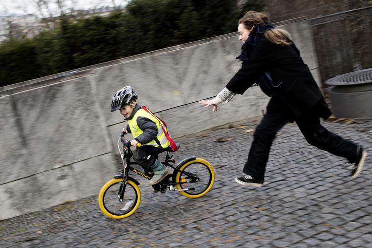 skal. For 11 år siden blev det obligatorisk for svenske børn at køre med cykelhjelm. Cyklisten på billedet, som sætter sin mor, er fra Danmark. 