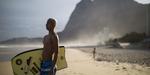 Surfing. Med boardet under armen holder en ung surfer øje med bølgerne på Sao Conrado-stranden i Rio de Janeiro, Brasilien. 
