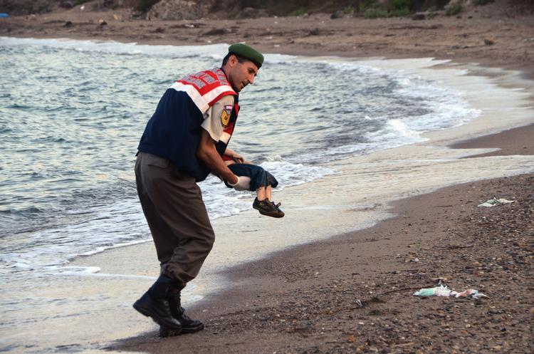 OMKOMMET. En tyrkisk betjent bærer liget af den 3-årige Aylan Kurdi væk fra stranden. 